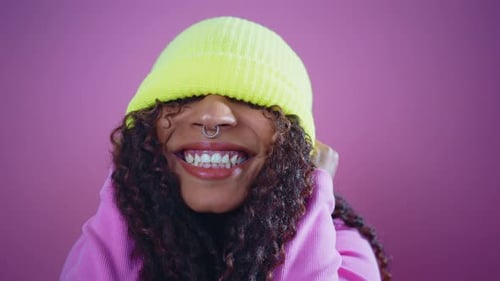 Energetic Young Adult in Yellow Beanie Pulls Funny Face