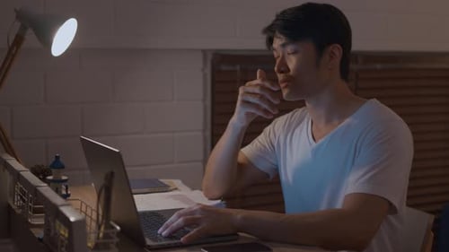 Young Adult Working at Laptop at Night