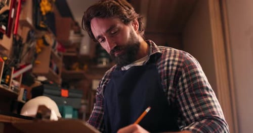 Carpenter man, writing checklist and workshop for reading, thinking or drawing sketch in planning