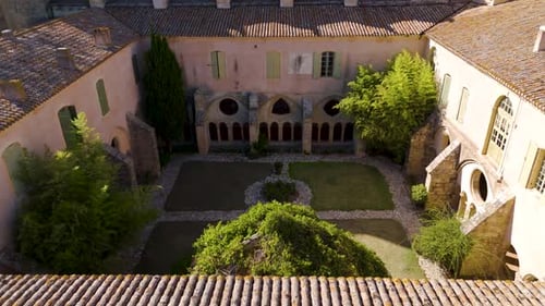 Aerial establishing shot of a luxury courtyard within a French Abbey at summer