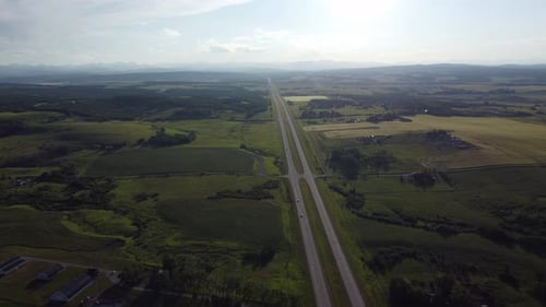 Vue statique prise par un drone de l'autoroute au coucher du soleil avec des montagnes en arrière-plan