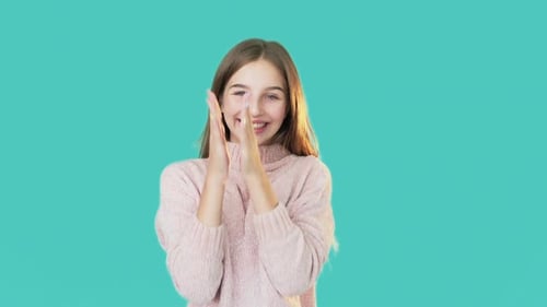 Teen Girl Smiles in Front of Blue Background