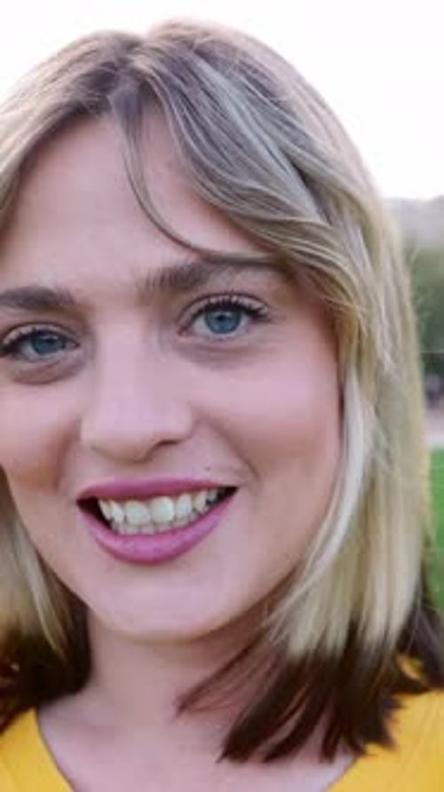 Portrait of Young Trendy Blonde Woman Looking at Camera Standing at City Park