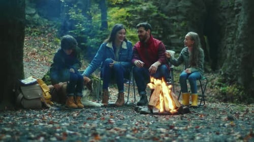 Smiling Family Sits Near Campfire on Autumn Evening Children with Their Parents are Resting in the