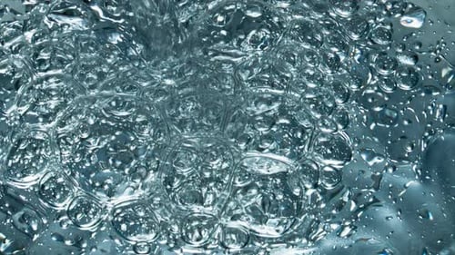 Small Air Bubbles Rising Up to Water Surface Closeup