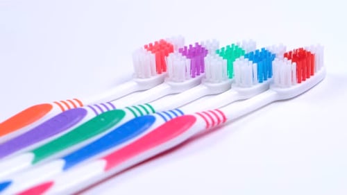 Background Dental Toothbrushes of Different Colors on a White a Background Top View