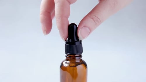 Dropper Placing Clear Liquid into Bottle