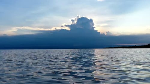 Sonnenuntergang auf See mit einer Wolke im Hintergrund
