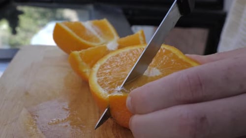 Junge männliche Scheiben in Orange in heller Küche
