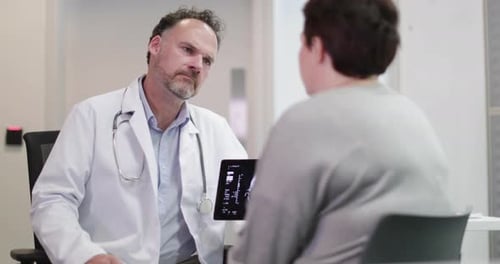 Doctor Explains Scan Results to Patient in Office