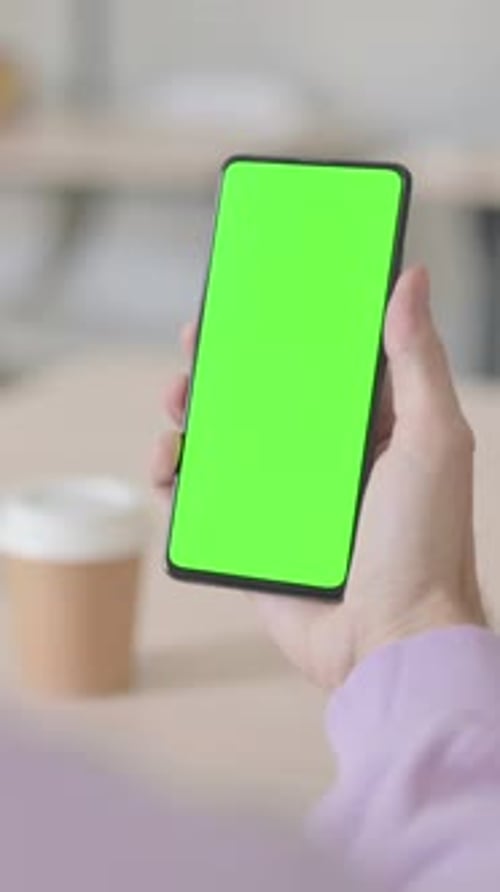 Rear View of Man Looking at Smartphone with Green Chroma Screen, Vertical Video