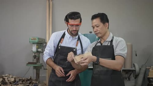 Carpenters are working together at workshop.