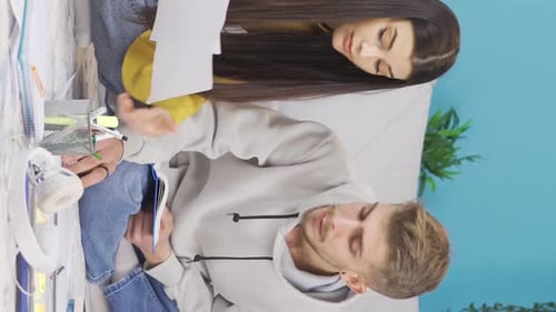 Vidéo verticale d'un jeune homme et d'une jeune femme étudiant à la maison. Des amis d'université et d'école.
