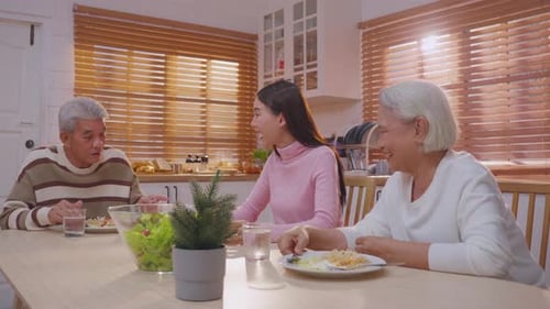 Three People Enjoying Meal and Conversation in Kitchen