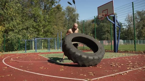 Un athlète en entraînement soulève un gros pneu lourd