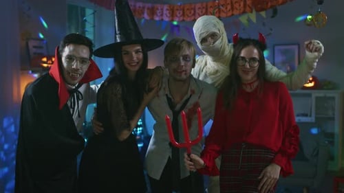 Group of friends celebrate Halloween in costume indoors