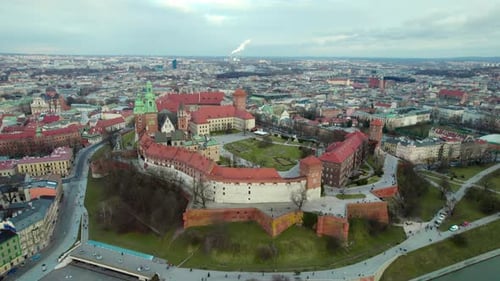 Cinematic aerial establishing shot flying over Krakow Wawel Royal Castle moving forward, city center