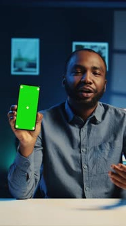 Man Holding Smartphone with Green Screen Talking