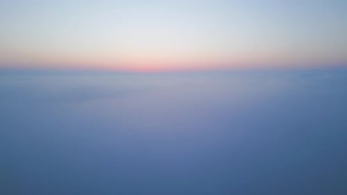 Aerial Drone View Above Clouds at Sunrise Highaltitude Misty Landscape with Rolling Fog and Golden