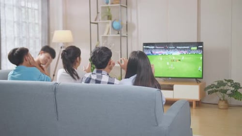 Teenagers Cheering And Watching Football Game On Tv. Team Celebrating Victory And Team Disappointed