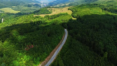 Mountain valley with road between green hills.