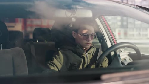 Young Adult Fastens Seatbelt in Car, Daytime