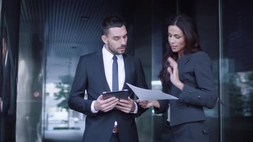 Business Professionals Discussing Data on Tablet and Paper