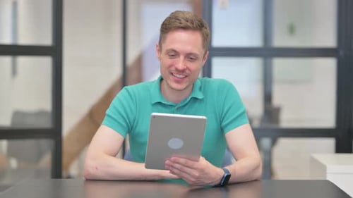 Man Video Conferencing Using Tablet in Office Setting