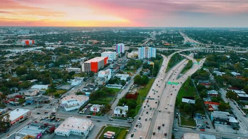 Green cityscape of modern American metropolis with busy highway in the middle.