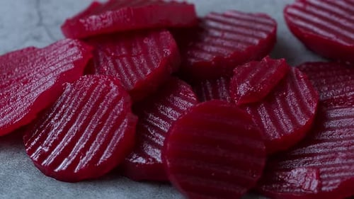 Slices of pickled red beets on black background