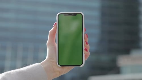 Woman Hands Demonstrating Phone with Chroma Key on the Office Building Background Green Screen
