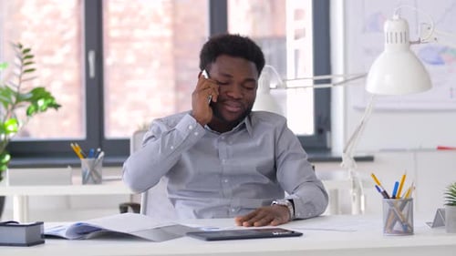 African american businessman working in his office calling on his smartphone
