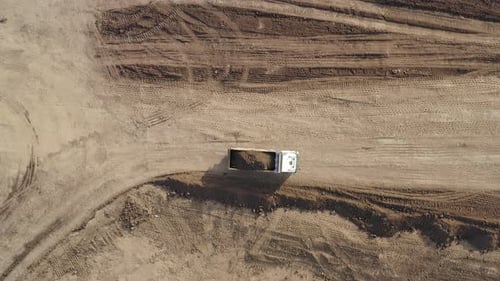 Large Truck hauling a full load of Excavated Soil on a dirt road.
