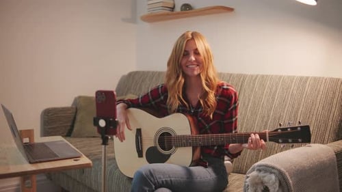 Woman Plays Guitar and Records Video at Home