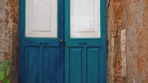 Puerta pintada de azul en una casa rústica en la ciudad siciliana de Marzamemi