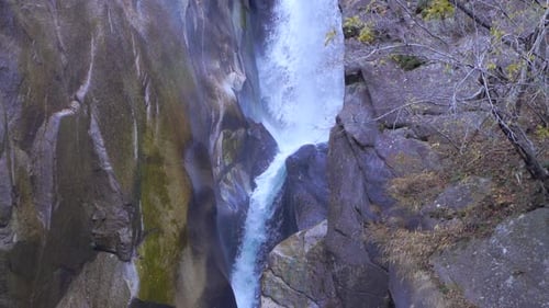 Waterfall in between rocks falling in slow motion
