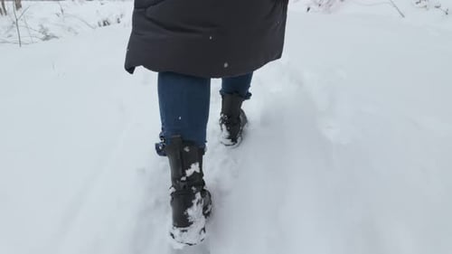 Following Footsteps Of A Person Walking Through The Snowy Path During Snowfall In Winter. - close up