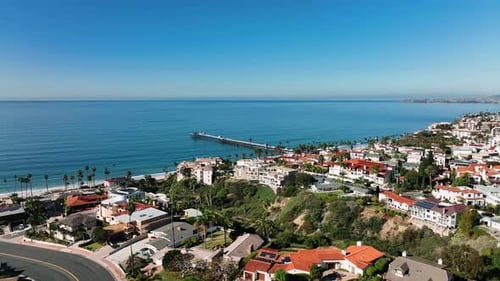 Slow motion aerial view of San Clemente coastline and beach during blue sky day. San Clemente city,