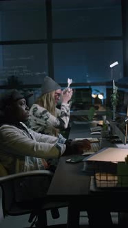 Zwei verschiedene Programmierer arbeiten nachts im Büro an Computercode