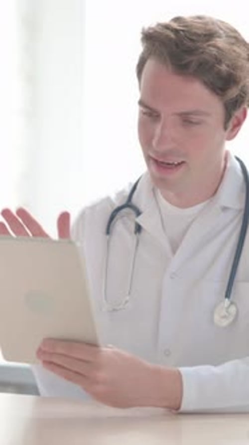 Online-Videoanruf auf Tablet von Young Doctor, Vertikales Video