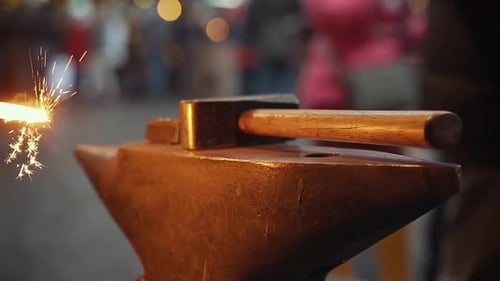 Slow motion close up of a burning horseshoe on an anvil