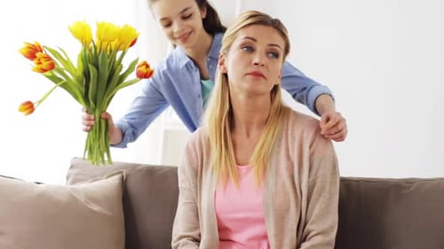 Young Girl Giving Flowers to Her Mother