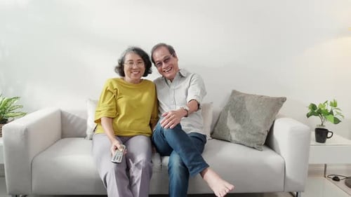 Elderly Couple Relaxing Together on Sofa at Home