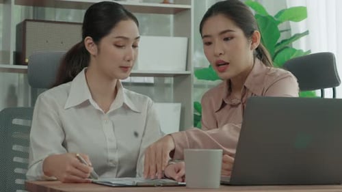 Two Young Enthusiastic Businesswoman Working Together in the Office Workspace