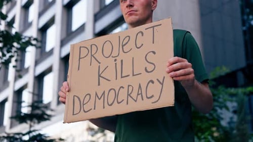 Gros plan : un manifestant avec une pancarte à la main, campagne présidentielle, corruption