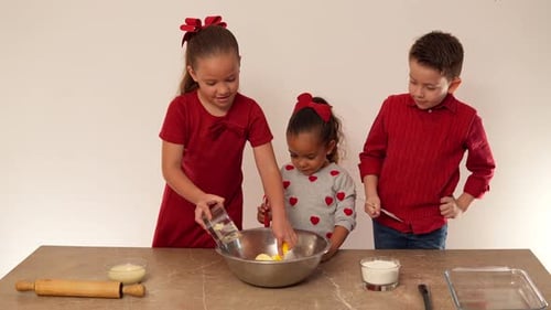 Kinder teilen und bereiten den Teig mit Butter und Mehl zu, um ihn zu kochen und Kekse zum Teilen zu backen