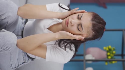 Woman Rubbing Head Sitting Indoors In Pain