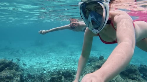 Underwater Shot Of Young Couple Swimming Together In Tropical Ocean On Maledives