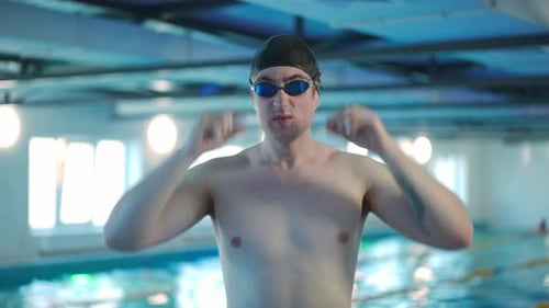 Medium Shot Portrait of Confident Young Sportsman Looking at Camera Putting on Goggles
