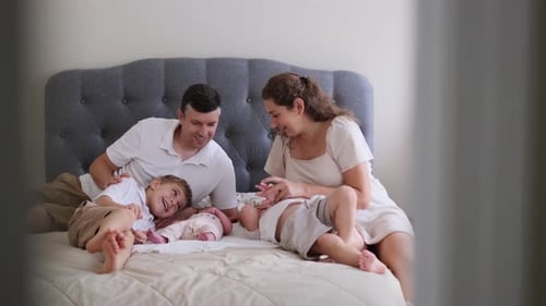 Happy Family Relaxing Together on Bed at Home
